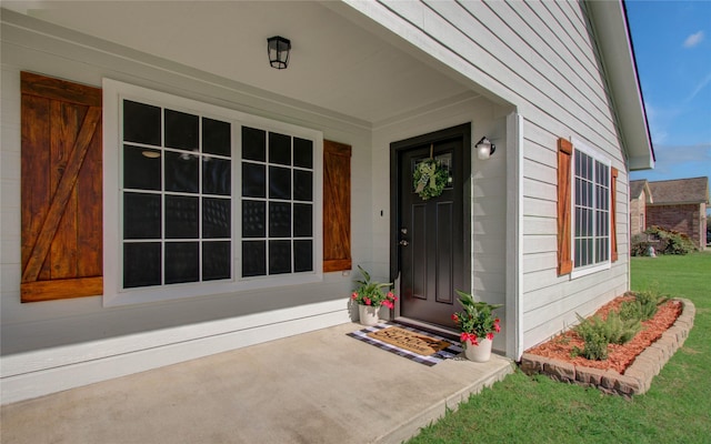 entrance to property featuring a lawn