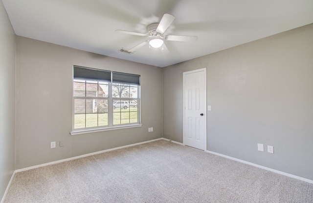 unfurnished room featuring baseboards, visible vents, carpet floors, and ceiling fan