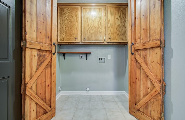 clothes washing area with baseboards, hookup for a washing machine, light tile patterned flooring, cabinet space, and electric dryer hookup