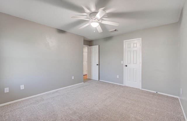 empty room with ceiling fan, visible vents, baseboards, and light carpet