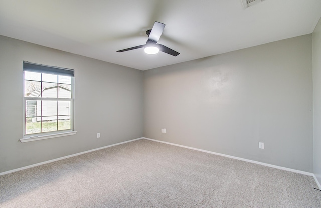 spare room with carpet flooring, baseboards, and ceiling fan