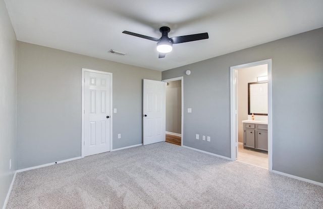 unfurnished bedroom featuring light carpet, visible vents, connected bathroom, and baseboards