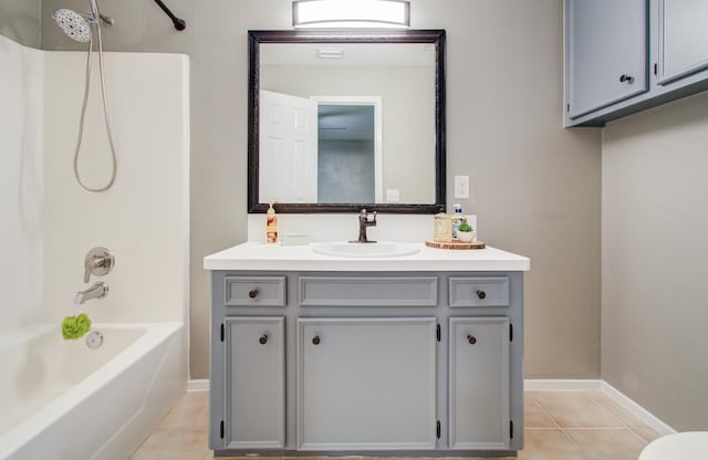 full bath featuring tub / shower combination, baseboards, vanity, and tile patterned flooring