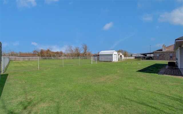 view of yard featuring an outbuilding, a storage shed, and fence