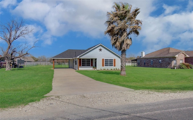 view of front facade with a carport, driveway, a front yard, and fence