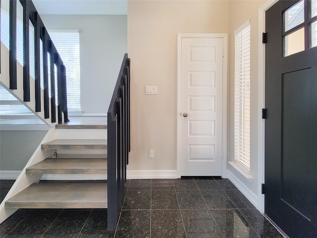 foyer entrance with baseboards, stairs, and granite finish floor