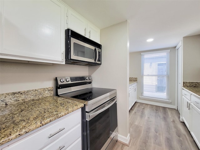 kitchen featuring white cabinetry, recessed lighting, appliances with stainless steel finishes, light wood finished floors, and light stone countertops