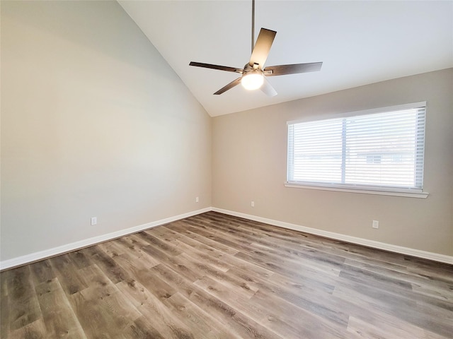 empty room featuring baseboards, wood finished floors, a ceiling fan, and vaulted ceiling