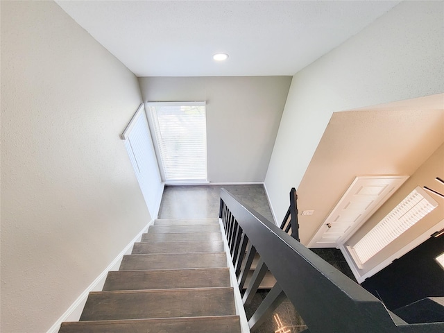 staircase featuring baseboards and wood finished floors