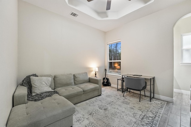 living room with visible vents, ceiling fan, a healthy amount of sunlight, and a tray ceiling