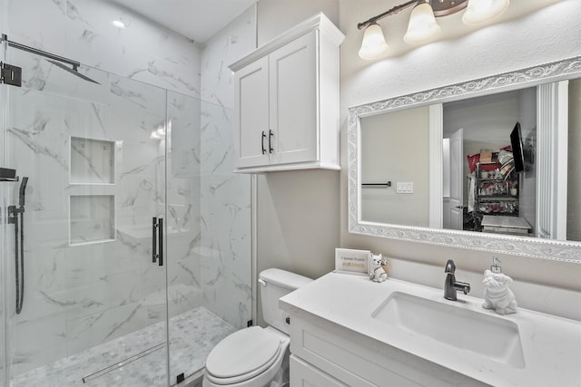 full bathroom featuring a marble finish shower, toilet, and vanity