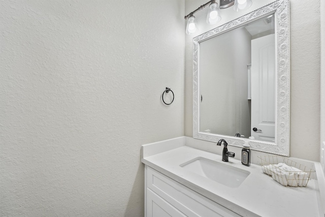 bathroom with vanity and a textured wall