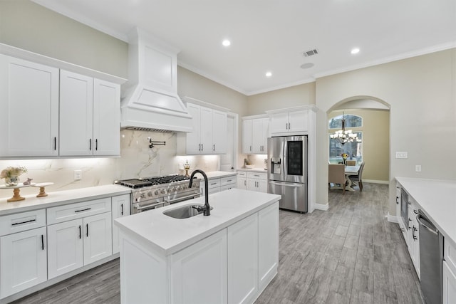 kitchen with visible vents, custom exhaust hood, a sink, stainless steel appliances, and tasteful backsplash