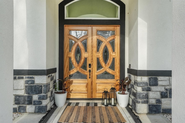 doorway to property featuring stucco siding