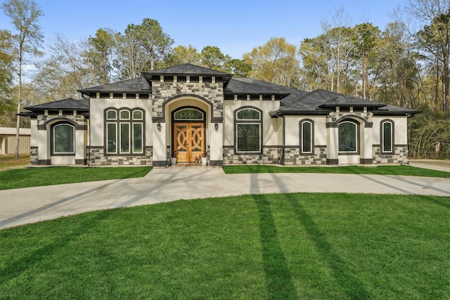 view of front of house with a front lawn, stone siding, and stucco siding