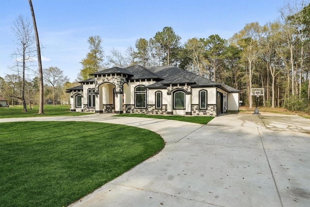 view of front facade featuring stucco siding, curved driveway, and a front yard