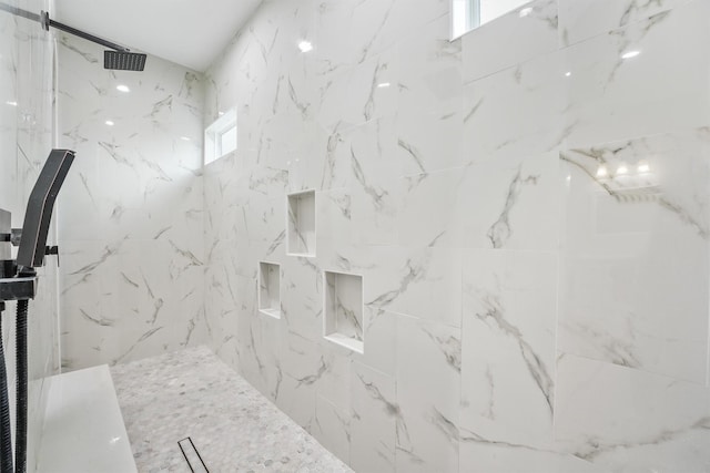 bathroom featuring a marble finish shower