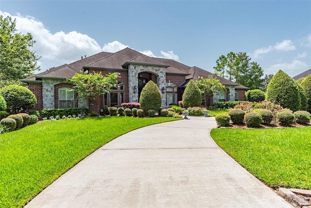 view of front of property with a front yard and brick siding