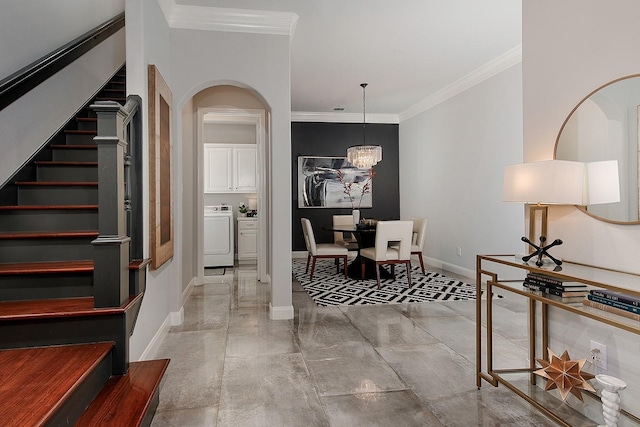 entrance foyer featuring stairway, arched walkways, crown molding, baseboards, and washer / dryer