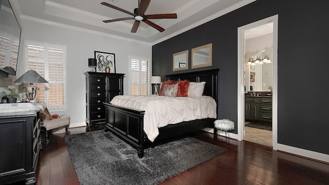 bedroom with a tray ceiling, crown molding, baseboards, and dark wood-style flooring