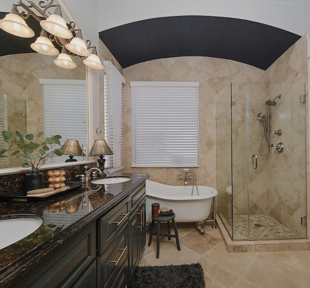 full bathroom with a freestanding tub, a sink, tile walls, a shower stall, and double vanity