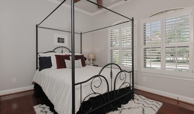 bedroom with crown molding, baseboards, and wood finished floors