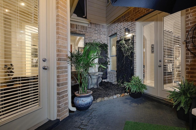 property entrance featuring french doors and brick siding