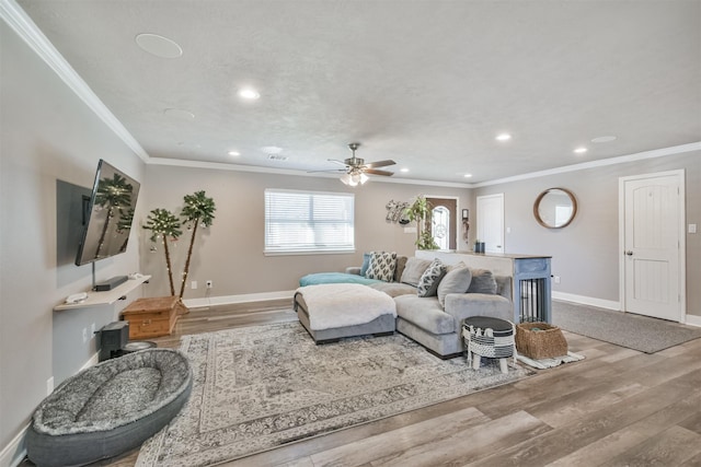 living room featuring recessed lighting, crown molding, baseboards, and wood finished floors