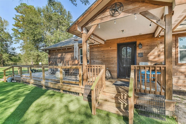 entrance to property with a lawn and a wooden deck