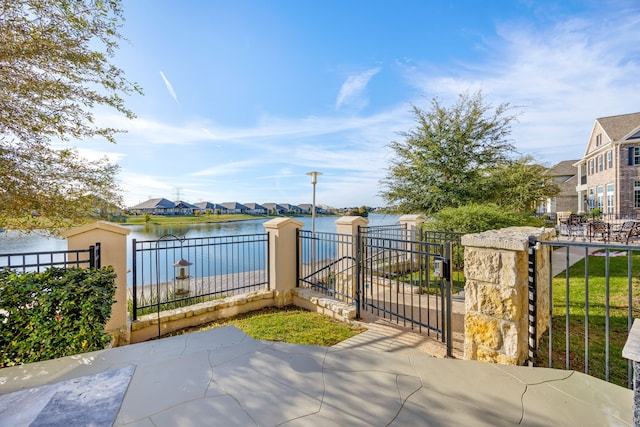 view of patio / terrace featuring a gate, fence, and a water view