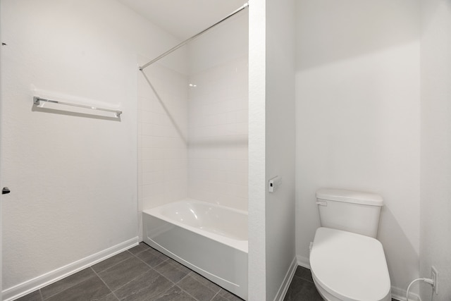 bathroom with tile patterned floors, toilet, baseboards, and shower / washtub combination