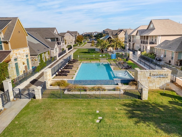 pool featuring a residential view, a yard, and fence