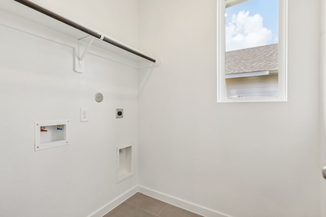 washroom with dark tile patterned flooring, baseboards, hookup for an electric dryer, hookup for a washing machine, and laundry area