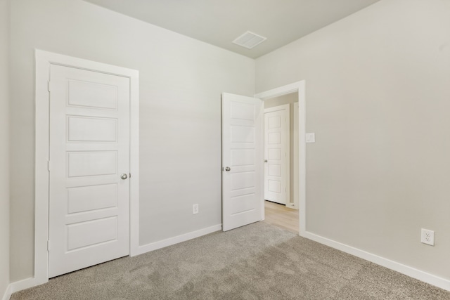 unfurnished bedroom featuring baseboards and light colored carpet