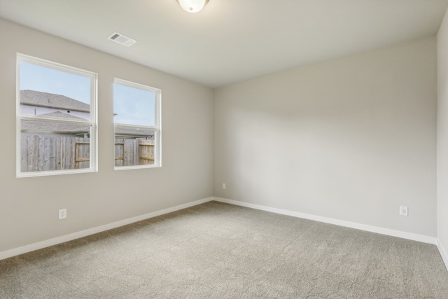 empty room featuring visible vents, baseboards, and carpet floors