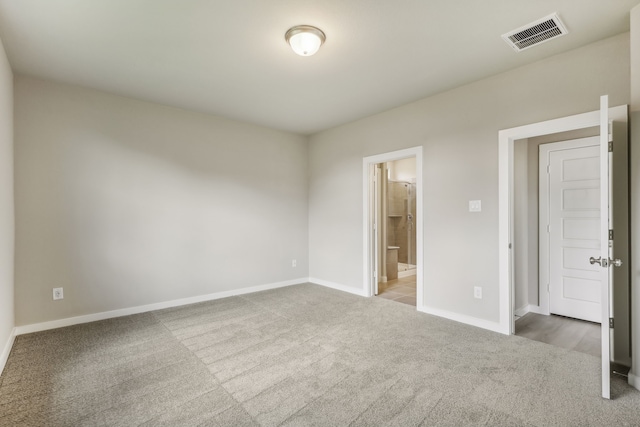 unfurnished bedroom with visible vents, baseboards, carpet, and connected bathroom