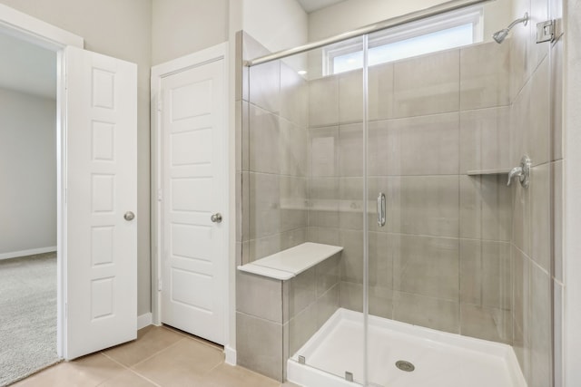 full bathroom with tile patterned flooring and a shower stall