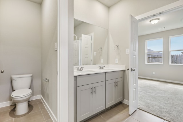 full bath with tile patterned flooring, double vanity, toilet, and a sink