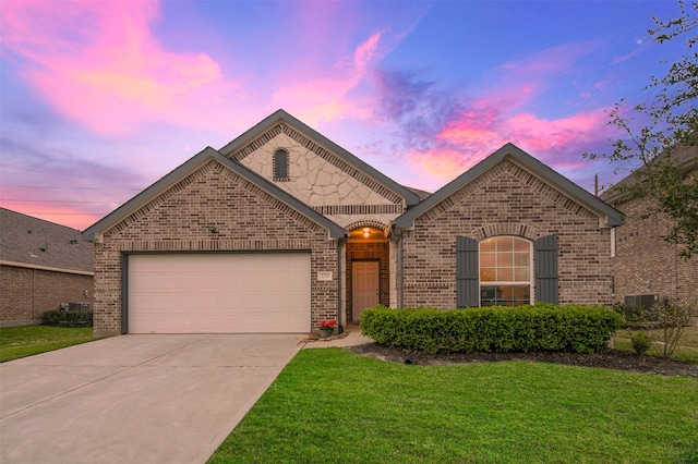 french provincial home featuring brick siding, driveway, a front lawn, and a garage