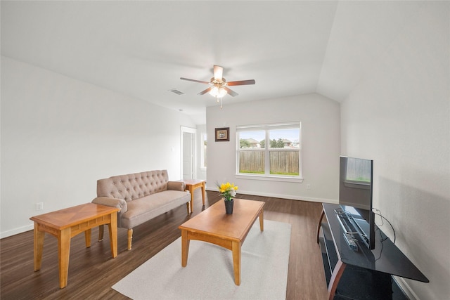 living area with dark wood finished floors, vaulted ceiling, a ceiling fan, and baseboards