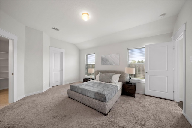 carpeted bedroom featuring visible vents, baseboards, and vaulted ceiling