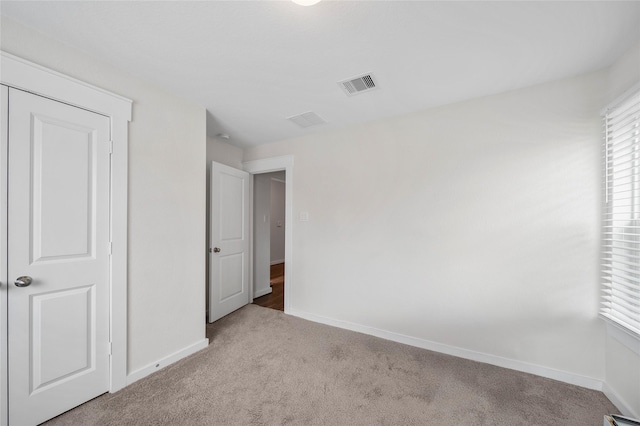 unfurnished bedroom with visible vents, baseboards, and carpet flooring