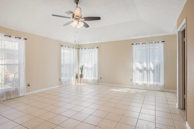 13930 Bonnercrest Dr, Houston, TX 77083 - empty room featuring ceiling fan, vaulted ceiling, light tile patterned floors, a textured ceiling, and healthy amount of natural light