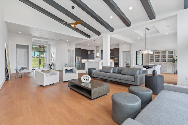 living area with light wood finished floors, beamed ceiling, and high vaulted ceiling