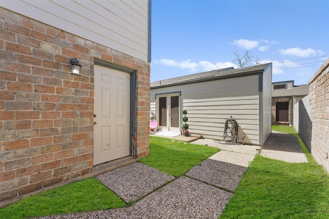 property entrance featuring french doors and brick siding