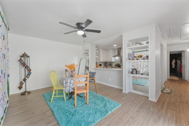 dining room featuring attic access, light wood-style floors, baseboards, and ceiling fan