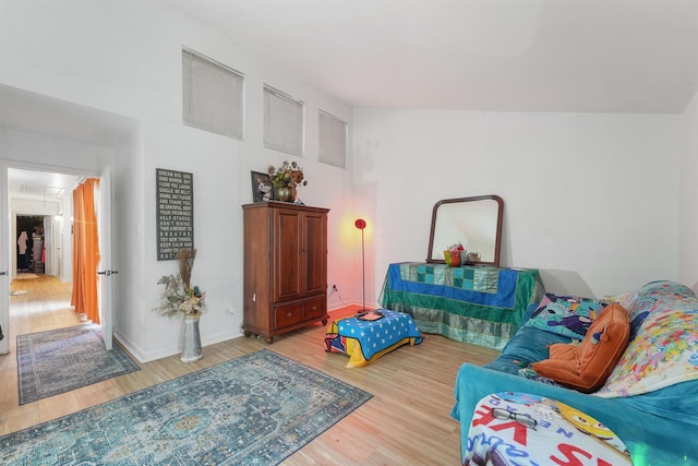 interior space featuring attic access, baseboards, and wood finished floors