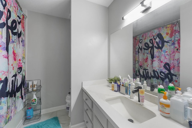 full bathroom with toilet, vanity, and baseboards