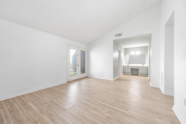 unfurnished living room with visible vents, baseboards, vaulted ceiling, and light wood-style floors