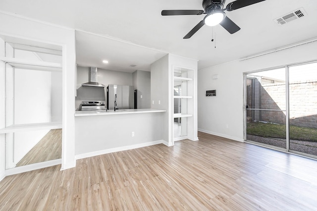 unfurnished living room featuring wood finished floors, built in shelves, baseboards, visible vents, and a ceiling fan